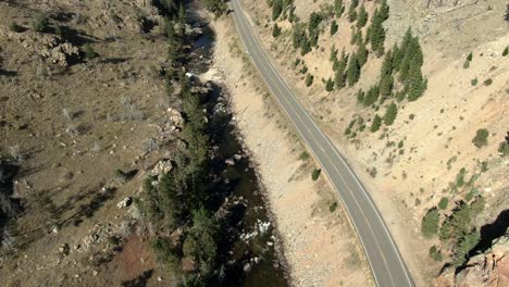 Aerial-forward-over-road-in-canyon-next-to-river-in-Colorado