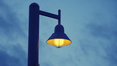 A-lamp-post-stands-defiantly-against-a-darkening-sky-as-clouds-slowly-roll-past