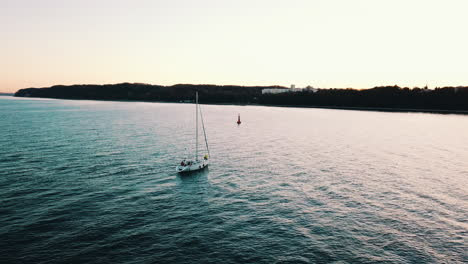 Drohne-Fliegt-über-Die-Yacht,-Die-Bei-Sonnenuntergang-In-Gdynia-In-Die-Bucht-Segelt