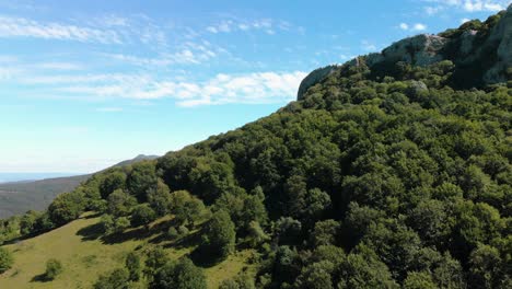 Aerial-footage-of-blue-sky,-white-clouds-and-cliffs-over-a-forest,-backwards-motion,-Kotel,-Bulgaria---October-15th,-2018