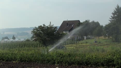 Sprinkler-irrigation-on-a-field-in-Bavaria,-Germany-1