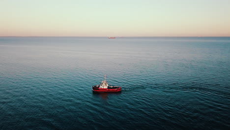 Drone-flying-above-the-fishing-boat-sailing-on-the-baltic-sea-at-the-sunset