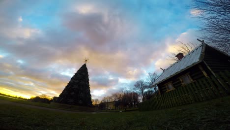 Dramatic-clouds-over-Christmas-tree-and-small-wooden-house