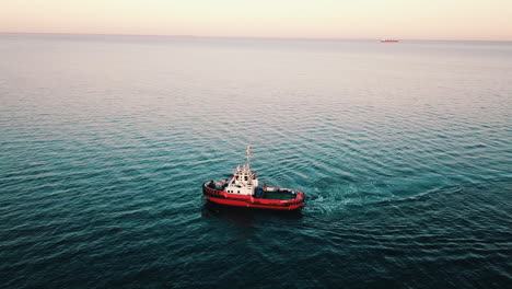 Drone-flying-over-the-fishing-boat-sailing-on-the-baltic-sea-at-the-sunset