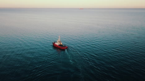 Drone-Volando-Sobre-Un-Barco-De-Pesca-Navegando-En-El-Mar-Al-Atardecer