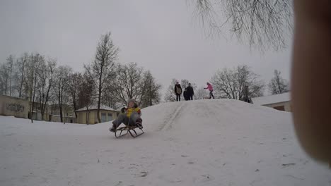 Lady-Child-Slide-Down-Icy-Hill-On-Toboggan-In-Winter-Vacations-1