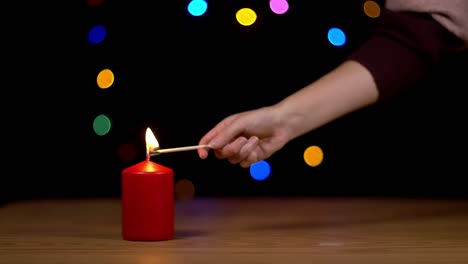 Lighting-a-christmas-candle-with-bokeh-background