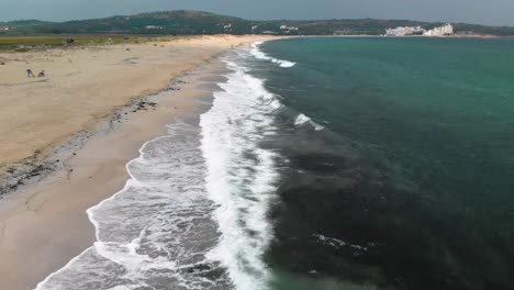 Aerial-footage---drone-shoot-parallel-to-sea-shore,-flying-above-waves-and-seagulls---Sozopol,-Bulgaria