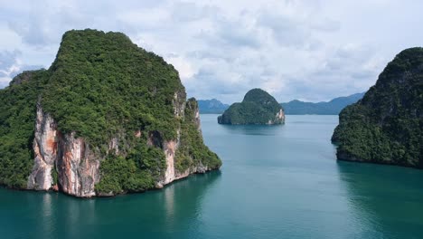 Drone-footage-of-islands-in-Thailand-with-limestone-rock-formation-sticking-out-of-the-water-and-the-ocean-in-background-14