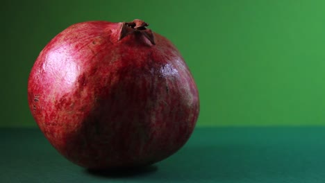 Pomegranate-In-Fast-Rotation-On-Green-Background