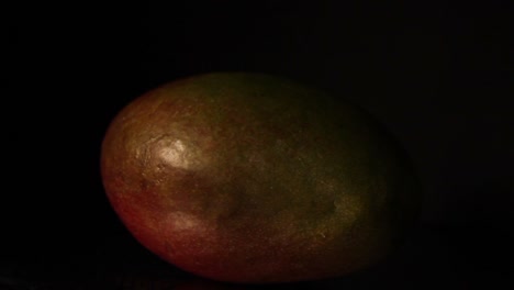 Das-Licht-Wandert-Im-Dunkeln-Nach-Links-Auf-Die-Frucht-Der-Mango