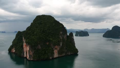 Drone-footage-of-islands-in-Thailand-with-limestone-rock-formation-sticking-out-of-the-water-and-the-ocean-in-background-15