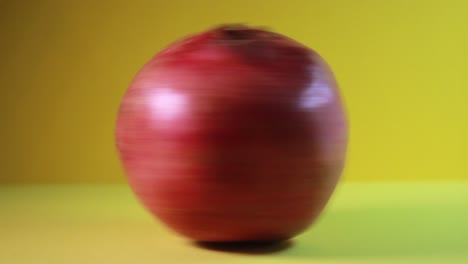 Pomegranate-In-Fast-Rotation-On-Yellow-Background