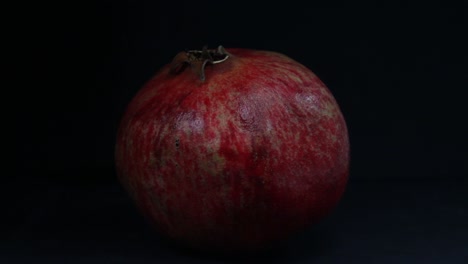 Granatapfelfrucht-Auf-Dem-Schwarzen-Hintergrund-Wird-Durch-Sich-Bewegendes-Licht-Beleuchtet