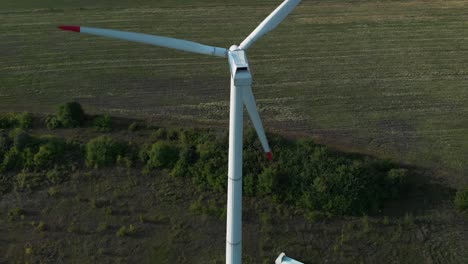 Aerial-drone-shot-around-single-wind-turbine-generator-in-grass-field-1