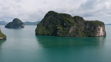 Drone-footage-of-islands-in-Thailand-with-limestone-rock-formation-sticking-out-of-the-water-and-the-ocean-in-background-11