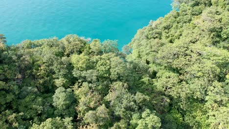Drone-footage-of-islands-in-Thailand-with-limestone-rock-formation-sticking-out-of-the-water-and-the-ocean-in-background-9