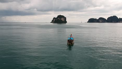 Drohnenaufnahmen-Von-Longtail-Booten,-Die-Um-Die-Inseln-Thailands-Navigieren,-Mit-Kalksteinformationen,-Die-Aus-Dem-Wasser-Ragen,-Und-Dem-Ozean-Im-Hintergrund-8