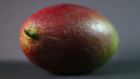 Close-Up-Of-Spinning-Mango-Fruit-On-a-Grey-Background