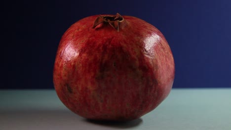 Pomegranate-In-Fast-Rotation-On-Blue-Background