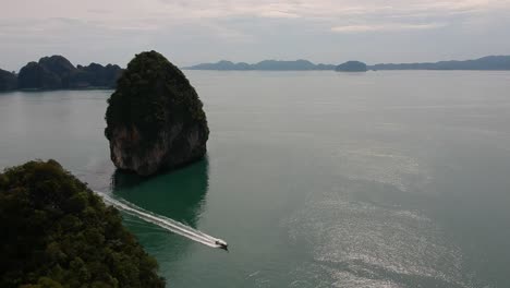 Drohnenaufnahmen-Von-Longtail-Booten,-Die-Um-Die-Inseln-Thailands-Navigieren,-Mit-Kalksteinformationen,-Die-Aus-Dem-Wasser-Ragen,-Und-Dem-Ozean-Im-Hintergrund-2