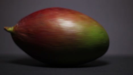 Close-Up-Of-Spinning-Mango-Fruit-On-a-Dark-Grey-Background