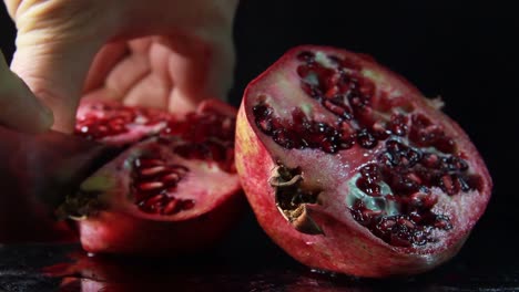 Cutting-Pomegranate-With-A-Knife-On-Black-Background
