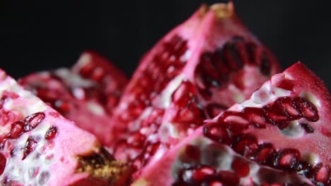 Extreme-Close-Up-Of-Cutted-Pomegranate-Fruit-And-Seeds-On-Black-Background