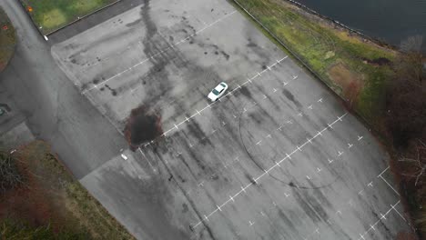 Aerial-footage-of-a-car-in-an-empty-parkinglot-drifting