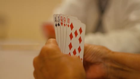 Hände-Einer-Frau,-Die-Karten-Hält-Und-Spielt