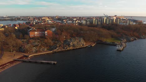 Aerial-footage-over-a-beach-in-Salto-Karlskrona,-Sweden-called-Saltosand-also-showing-a-school-on-the-mountain-2