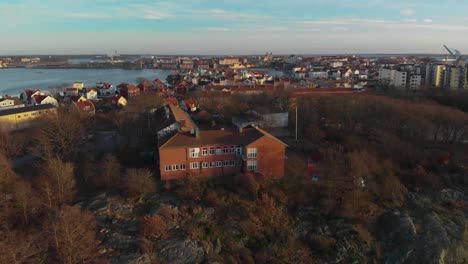 Aerial-footage-over-a-beach-in-Salto-Karlskrona,-Sweden-called-Saltosand-also-showing-a-school-on-the-mountain-3