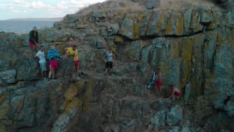 Boys-climb-seashore-cliff,-prepare-for-jump-in-the-water,-Bulgaria