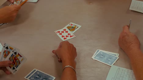 Nahaufnahme-Der-Hände-Von-Vier-Personen,-Die-Ein-Kartenspiel-Spielen