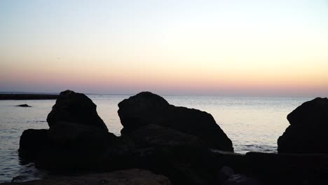 Sunrise-seashore-with-rocks-in-foreground