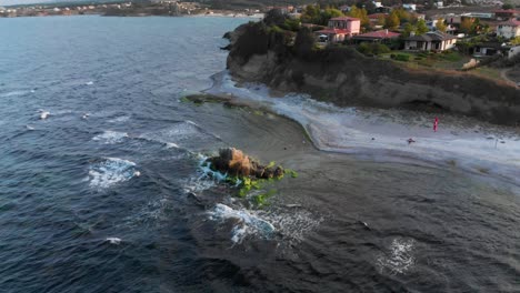 Aerial-panning-shot,-drone-fly-around-seashore-cliffs-and-beach-houses-1