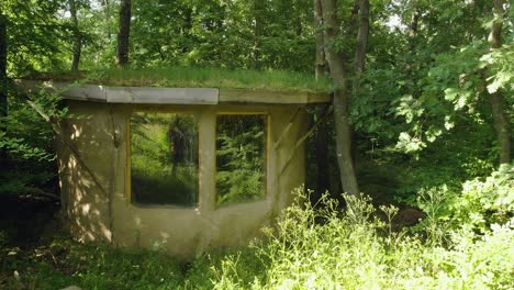 Schwenkaufnahme-Eines-Kleinen-Lehmhauses-Mit-Grasdach-Im-Wald,-Sommerzeit,-Bulgarien
