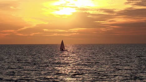 Zeitlupen-Segelboot-Segelt-Durch-Den-Sonnenuntergang-In-Ruhigen-Gewässern