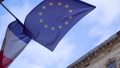 Waving-flag-of-France-and-Europinian-union-in-front-ofe-the-blue-sky
