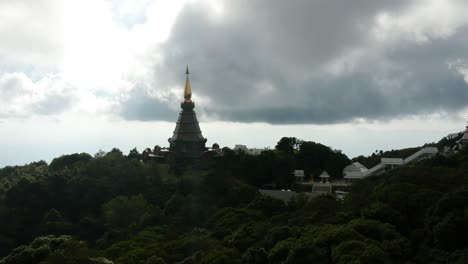 Footage-of-drone-flying-over-the-Temple-Doi-Inthanon-in-Chiang-Mai-in-Thailand-with-the-ocean-bellow-in-the-backgroung