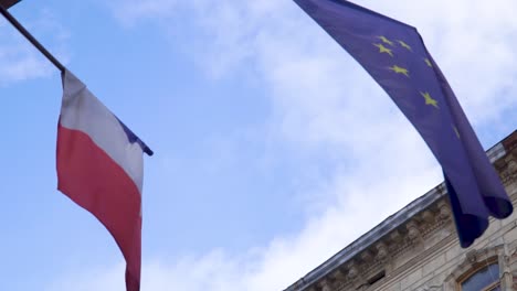 Waving-flags-of-France-and-European-Uninion-with-blue-sky-on-the-background