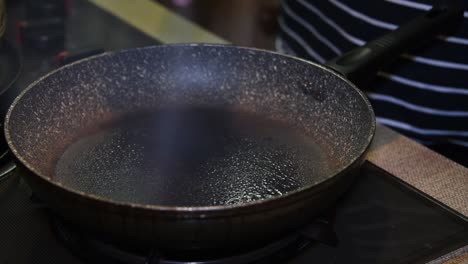 Frying-pan-getting-sprayed-with-olive-oil