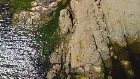 Vertical-aerial-shot-of-rocky-sea-cost-in-sunny-summer-day-2