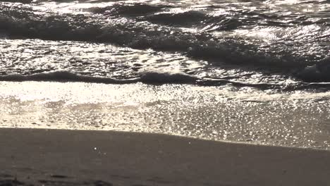 Slow-motion-waves-gently-lap-on-dark-shore