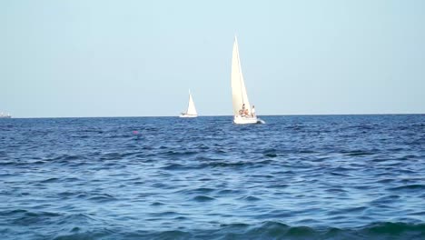 Yacht-Mit-Menschen,-Die-Auf-Den-Wellen-Schwimmen