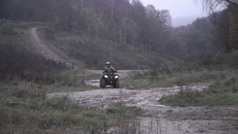 A-man-rides-quad-with-a-girl-in-misty-weather