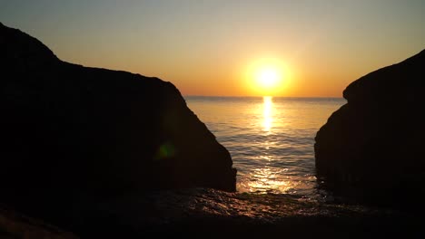 Sunrise-at-the-sea-beyond-rocks-on-the-shore