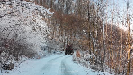 Tractor-drive-on-mountain-road-in-winter-day