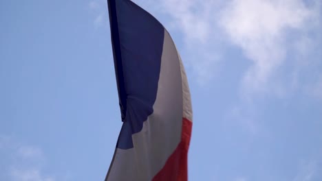 Ondeando-La-Bandera-De-Francia-Con-El-Cielo-Azul-En-El-Fondo