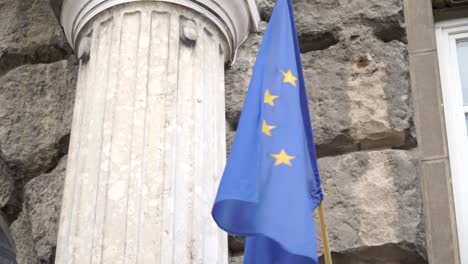 Waving-flag-of-European-union-in-front-of-stone-wall